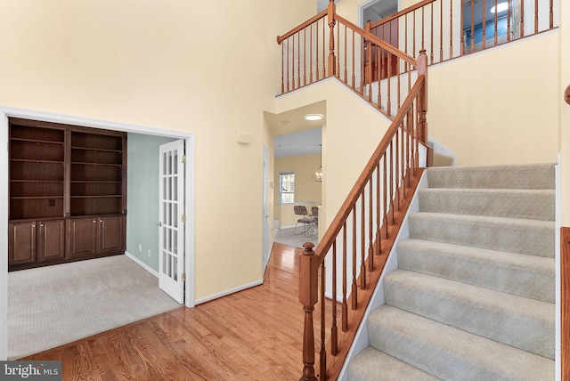 interior space with baseboards, a high ceiling, and wood finished floors