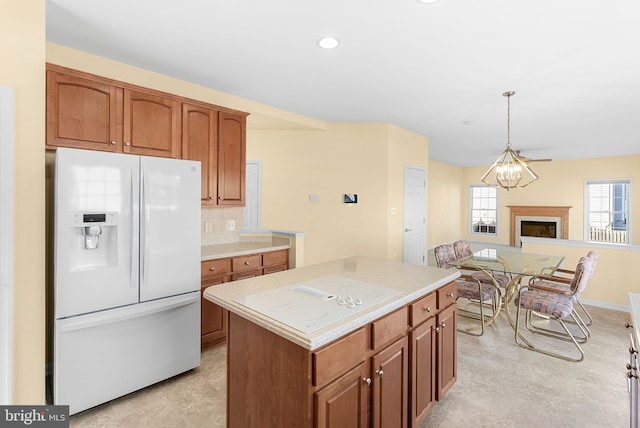 kitchen with white appliances, light countertops, backsplash, and a center island