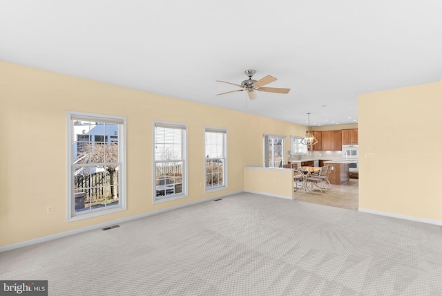 unfurnished living room with baseboards, visible vents, light colored carpet, ceiling fan, and recessed lighting