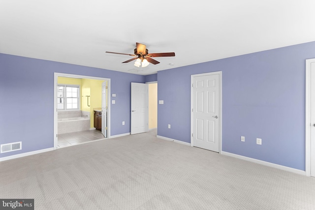 unfurnished bedroom with ensuite bathroom, light colored carpet, a ceiling fan, baseboards, and visible vents