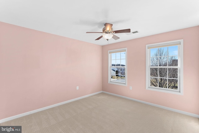 unfurnished room with visible vents, ceiling fan, light carpet, and baseboards