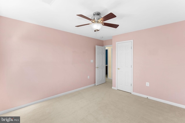 empty room featuring light carpet, a ceiling fan, and baseboards