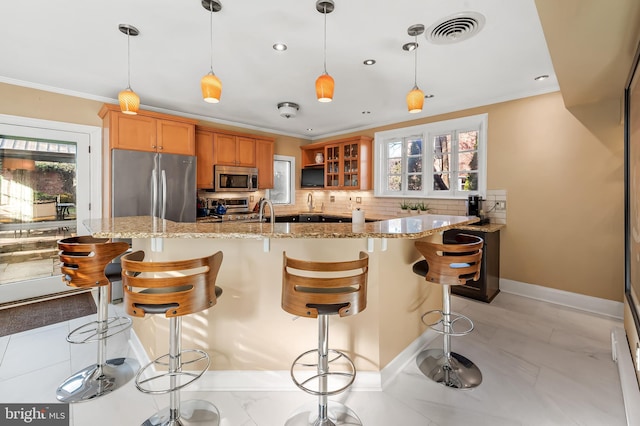 kitchen with stainless steel appliances, visible vents, ornamental molding, and decorative backsplash