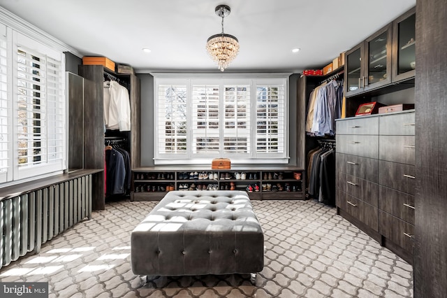 walk in closet with an inviting chandelier
