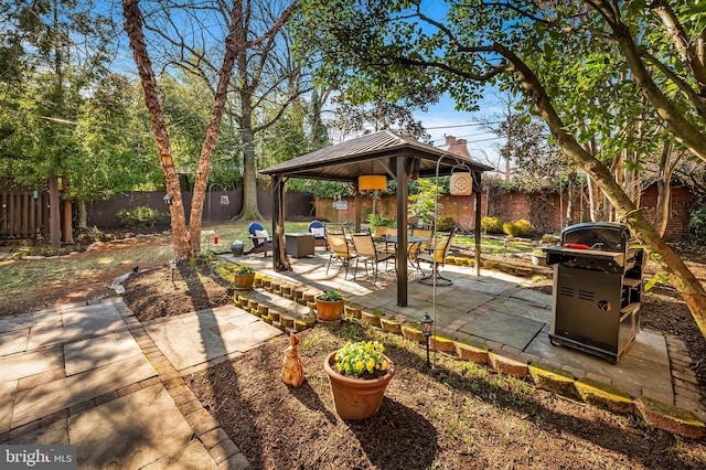 view of patio / terrace featuring a gazebo, a grill, and a fenced backyard