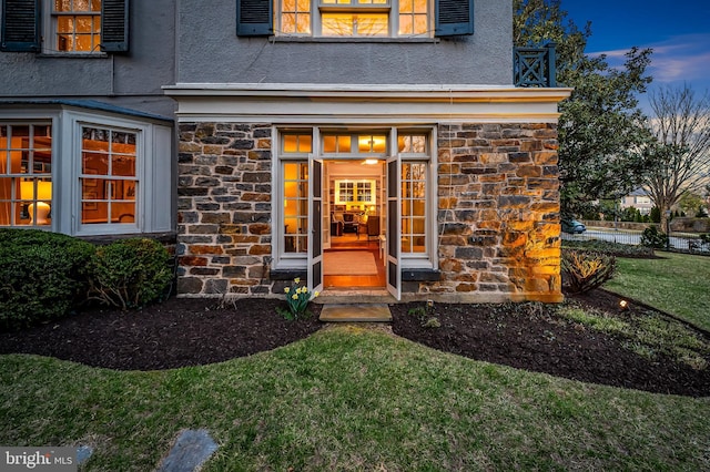 view of exterior entry with stucco siding and stone siding