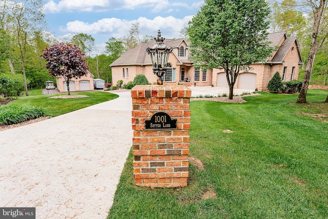 view of front of house featuring brick siding, concrete driveway, and a front yard