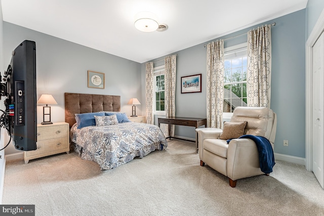 bedroom featuring visible vents, baseboards, and carpet