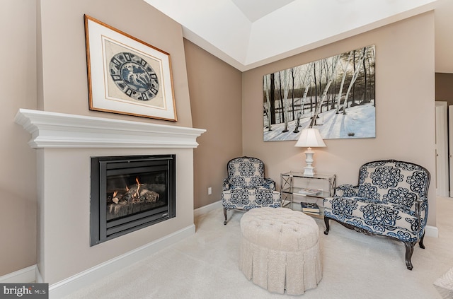 sitting room with a glass covered fireplace, baseboards, and carpet