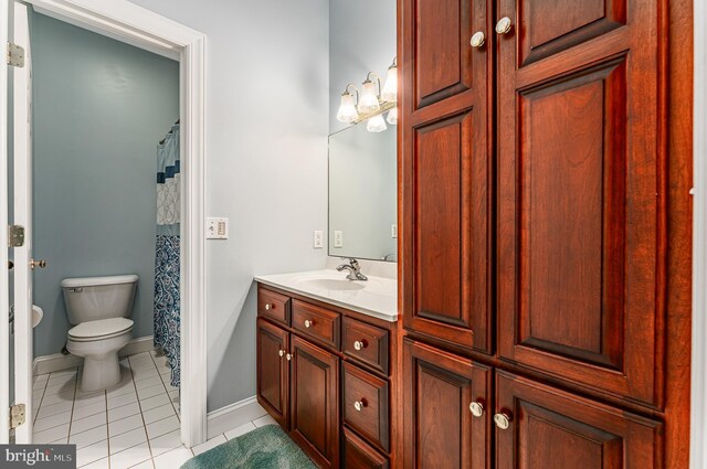 bathroom featuring tile patterned floors, baseboards, toilet, and vanity