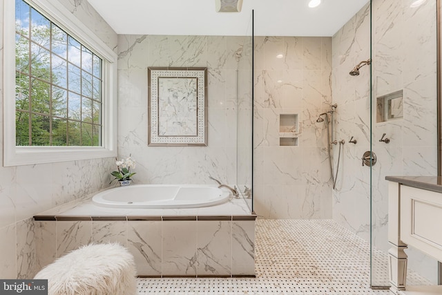 bathroom featuring a marble finish shower, tile walls, and a garden tub