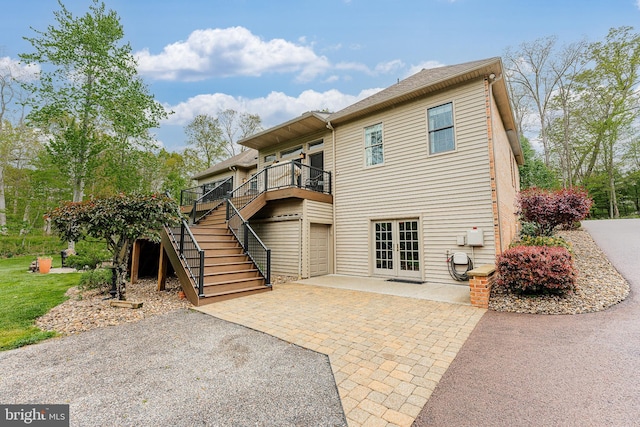 back of property featuring stairway, a patio, and french doors