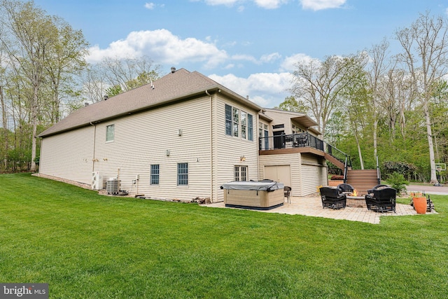 rear view of house featuring a patio, a yard, central AC unit, and a hot tub