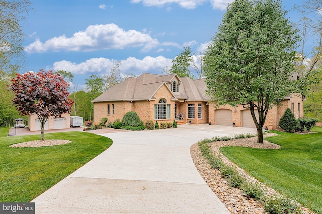 french provincial home featuring brick siding, an attached garage, concrete driveway, and a front lawn