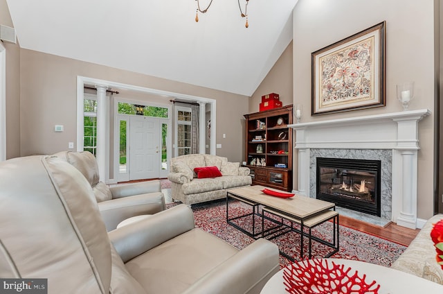 living area featuring a fireplace, vaulted ceiling, and wood finished floors