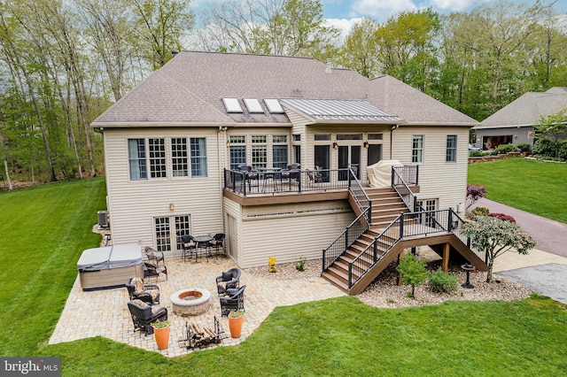 back of house featuring a hot tub, stairway, an outdoor fire pit, a deck, and a patio