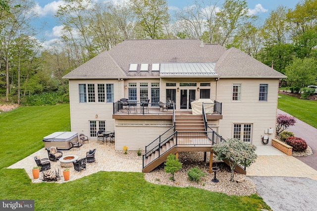 back of property featuring a lawn, a patio, an outdoor fire pit, a wooden deck, and stairs