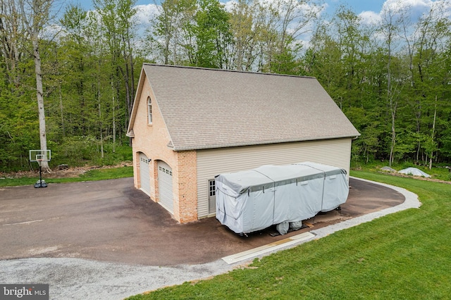 garage featuring a forest view and driveway