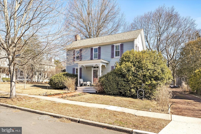 view of front of house featuring covered porch and a chimney