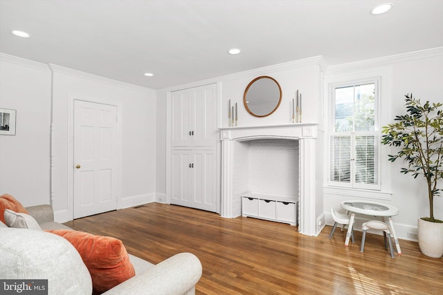 living room featuring recessed lighting, wood finished floors, baseboards, and ornamental molding