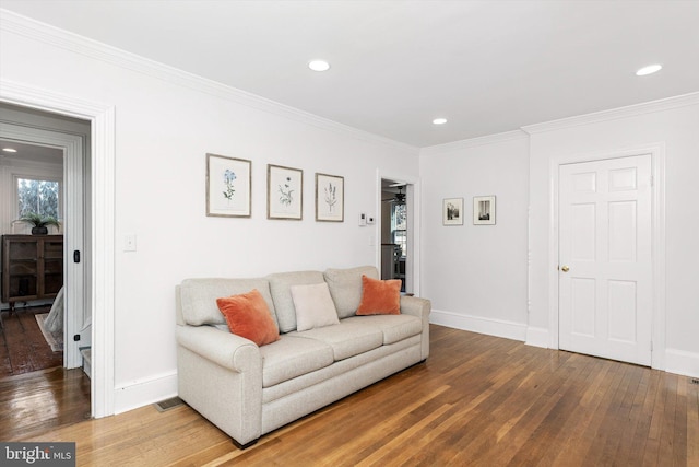 living room featuring recessed lighting, baseboards, wood-type flooring, and crown molding