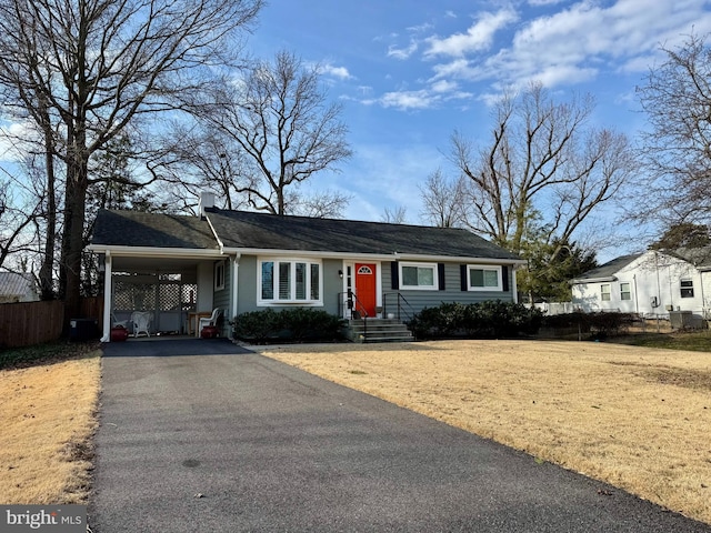 view of front of home featuring a front lawn, fence, aphalt driveway, and an attached carport