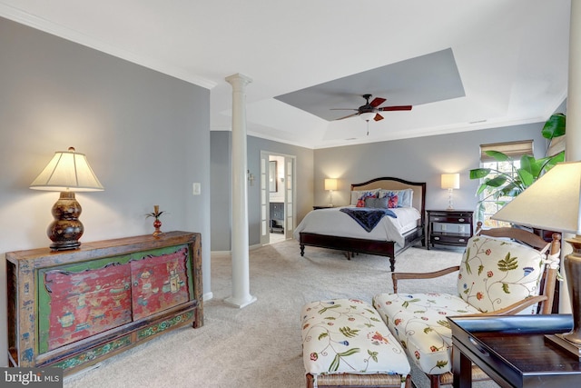 bedroom with carpet flooring, baseboards, ornamental molding, a tray ceiling, and ornate columns