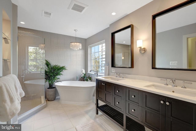 bathroom with a soaking tub, visible vents, and a sink