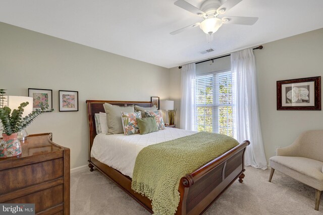 bedroom featuring baseboards, visible vents, a ceiling fan, and light colored carpet