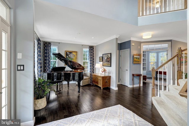 foyer entrance featuring crown molding, stairs, and wood finished floors