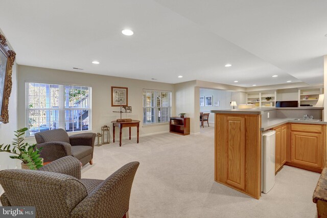 kitchen with light carpet, open floor plan, a sink, and recessed lighting