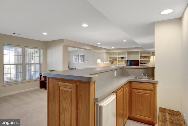 kitchen with recessed lighting, light colored carpet, open floor plan, a sink, and baseboards