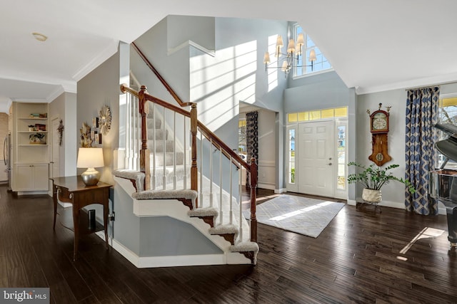 foyer featuring wood-type flooring, stairs, ornamental molding, and baseboards