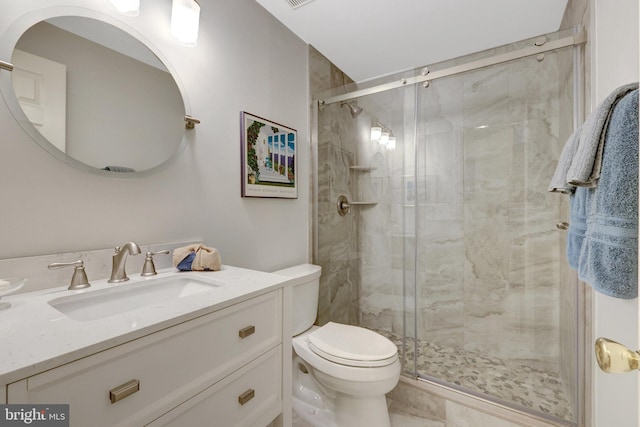 bathroom with a stall shower, vanity, and toilet