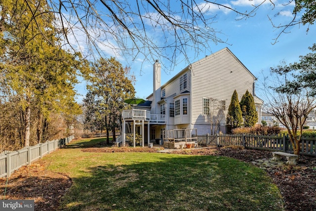 rear view of property featuring fence private yard, a yard, stairway, a wooden deck, and a chimney