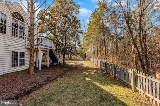 view of yard featuring a fenced backyard, stairway, and a wooden deck