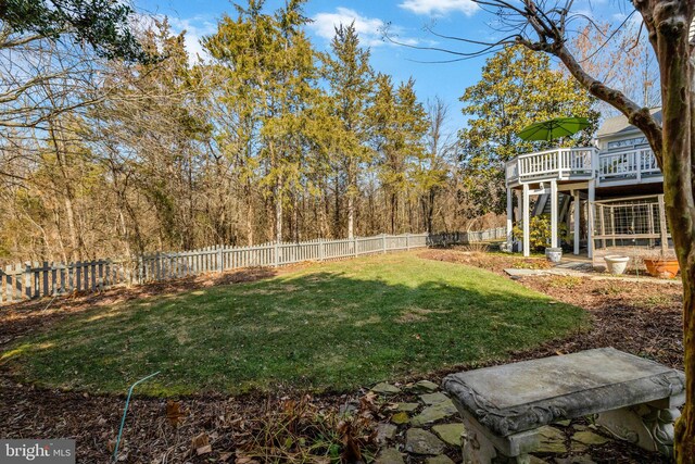 view of yard featuring a fenced backyard, a wooden deck, and stairs