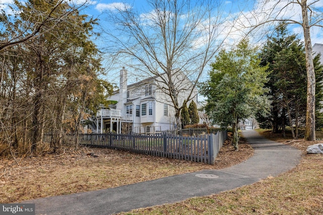 view of home's exterior featuring a fenced front yard and a chimney