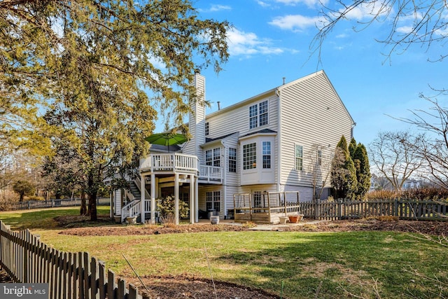 back of property with a lawn, a chimney, fence private yard, stairs, and a wooden deck