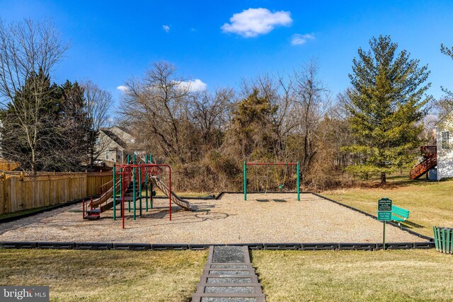 community play area featuring a lawn and fence