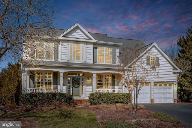 traditional-style house with aphalt driveway and covered porch