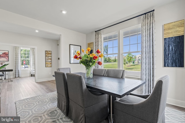 dining space with light wood-style floors, recessed lighting, and baseboards