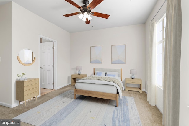 bedroom featuring baseboards, ceiling fan, and light colored carpet