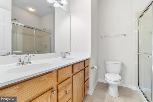 full bath with a sink, a shower stall, toilet, and tile patterned floors