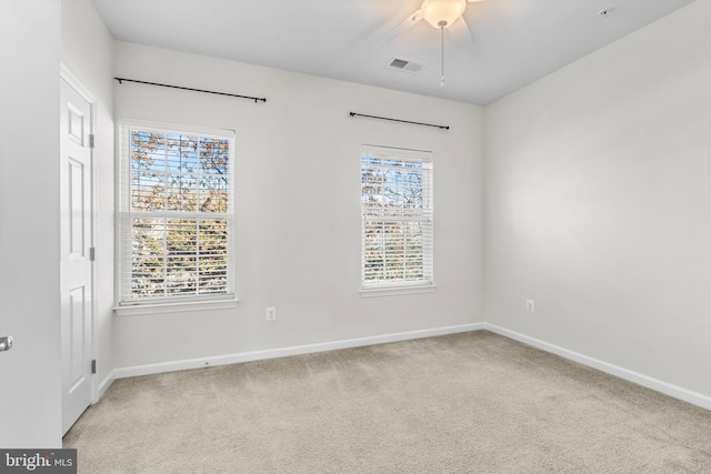 empty room featuring baseboards, plenty of natural light, visible vents, and carpet flooring