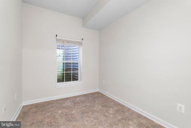 spare room with concrete floors and baseboards