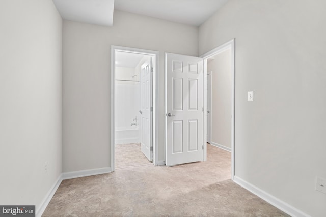 unfurnished bedroom with carpet, baseboards, and ensuite bathroom