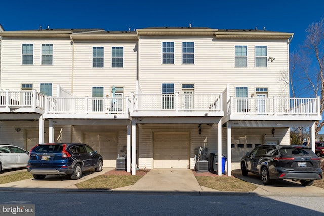 view of front of home featuring central AC, an attached garage, and driveway