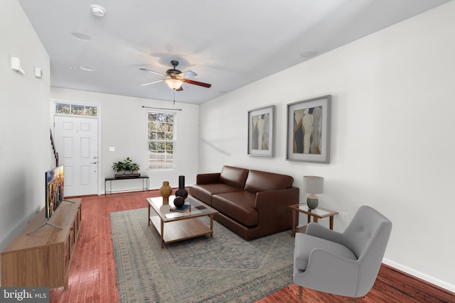 living area featuring ceiling fan, wood finished floors, and baseboards