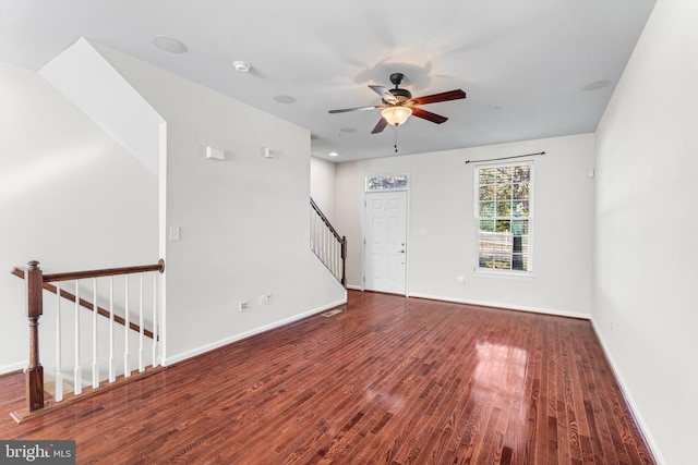 unfurnished room with stairway, wood finished floors, and baseboards